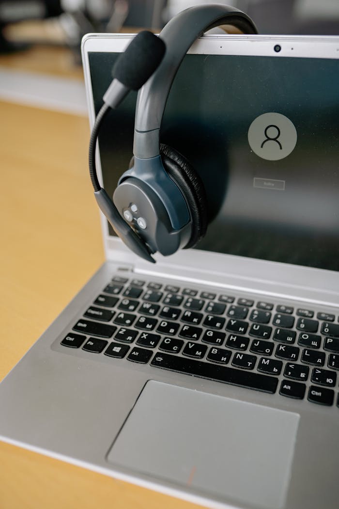 Close-up of a laptop with a headset, symbolizing online communication and remote work.